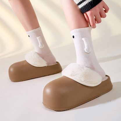 Chaussons douillets marrons Doudounea avec doublure chaude blanche, portés avec des chaussettes blanches décoratives, confort optimal pour enfant