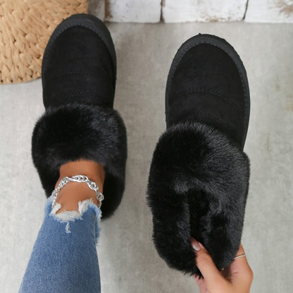 Chaussons d'hiver Doudounea en suède noir avec bordure en fausse fourrure luxueuse, portés avec un jean déchiré et un bracelet argenté