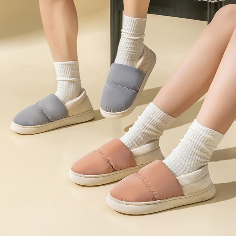 Chaussons matelassés Doudounea en gris et rose poudré, portés avec des chaussettes blanches, parfaits pour le confort intérieur en hiver