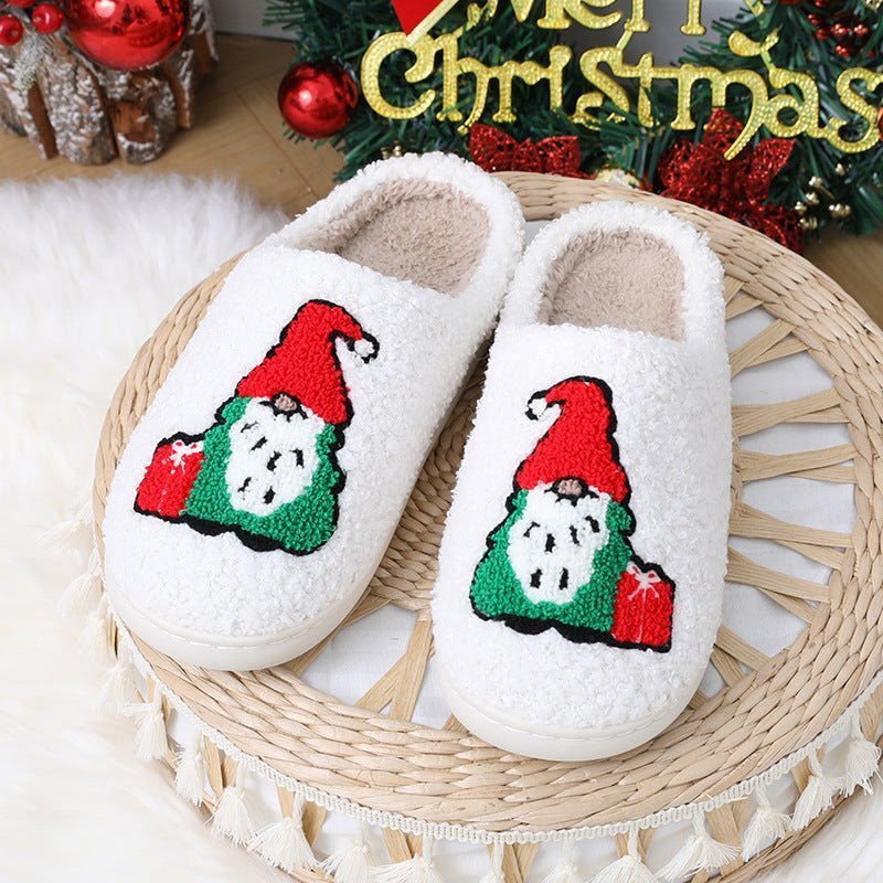 Chaussons de Noël Doudounea blancs douillets avec motif lutin festif, parfaits pour le confort hivernal avec une décoration de Noël en arrière-plan